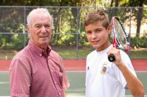 photo of senior man and youth on tennis court